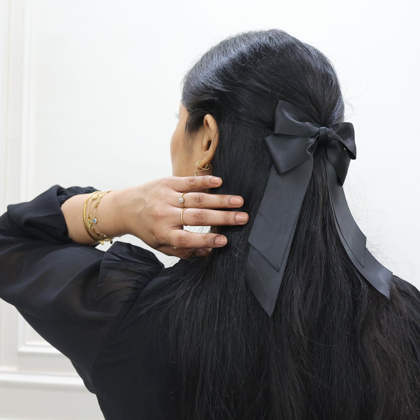 Model wearing Tesral Cascade Black Satin Bow, styled in a sleek half up and half down, showcasing polished finish and versatile elegance.