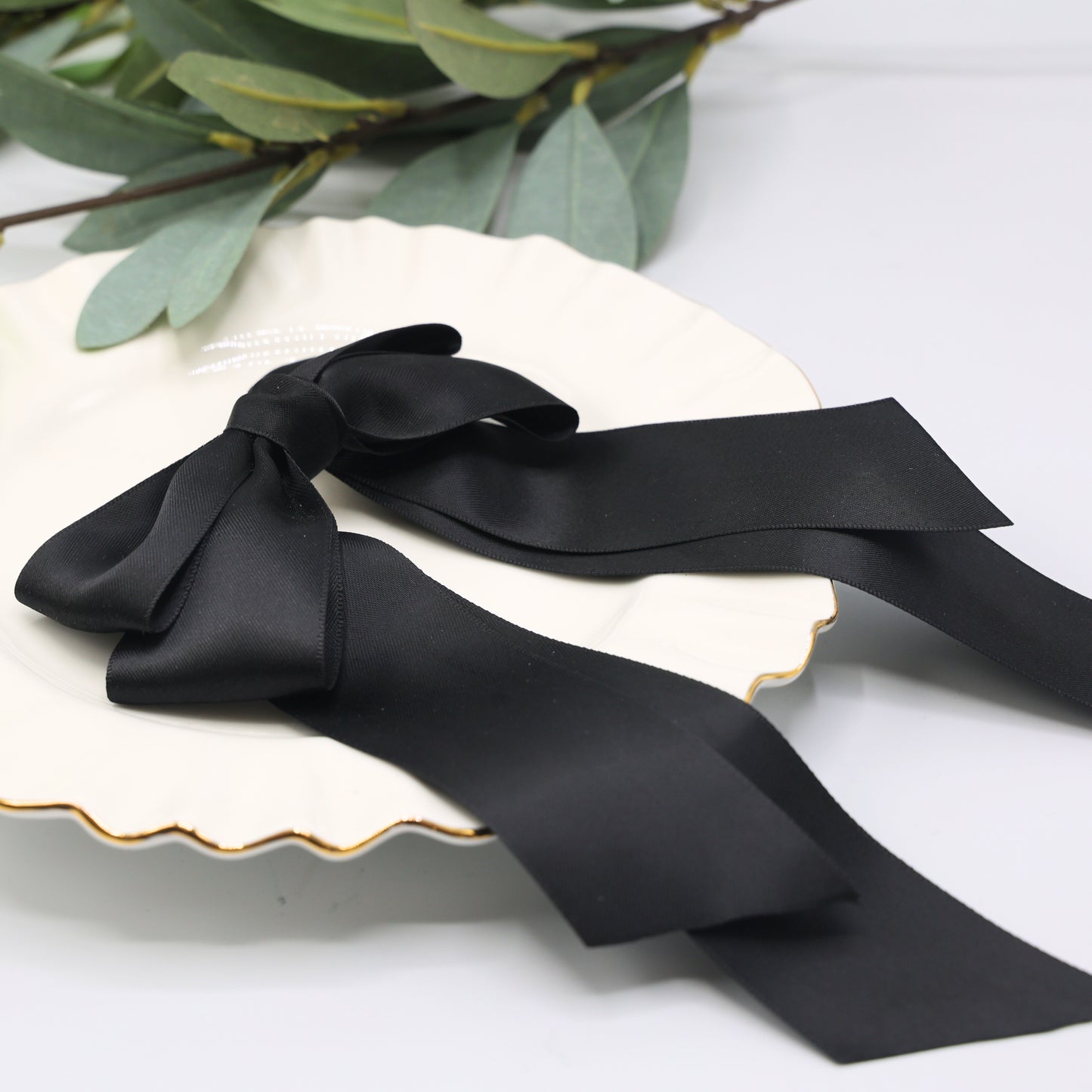 Close-up of Tesral Cascade Black Satin Bow, detailing luxurious sheen of double-sided satin ribbon and smooth edges.