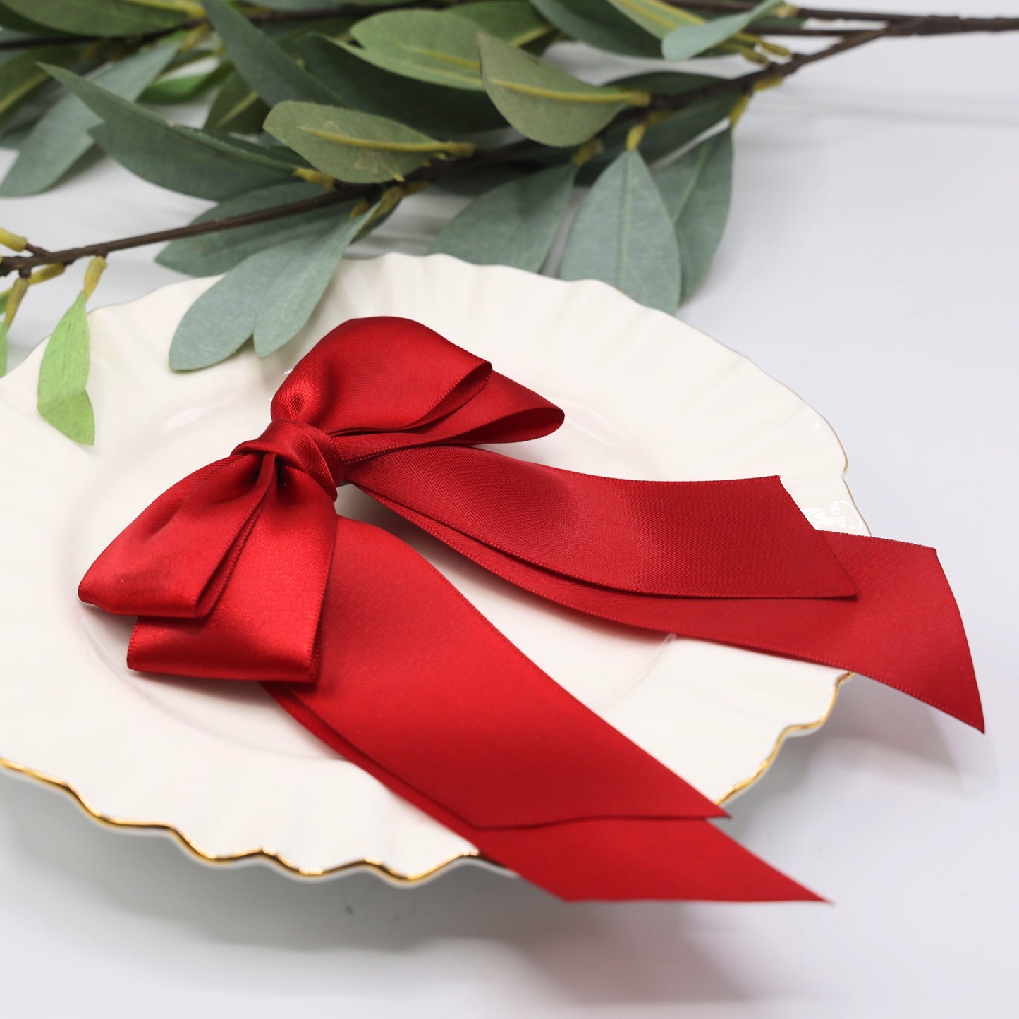 Close-up of Tesral Cascade Scarlet Red Bow, showcasing rich satin sheen, layered construction, and durable barrette.