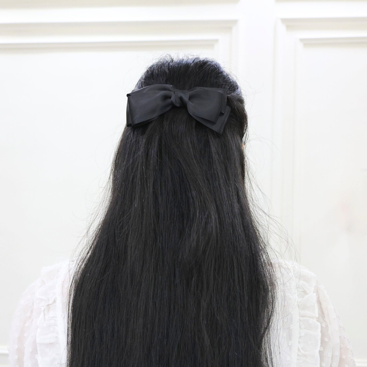 Model wearing Tesral Diana Bow in Black, displaying its formal elegance and sophisticated presence in an upscale hairstyle.
