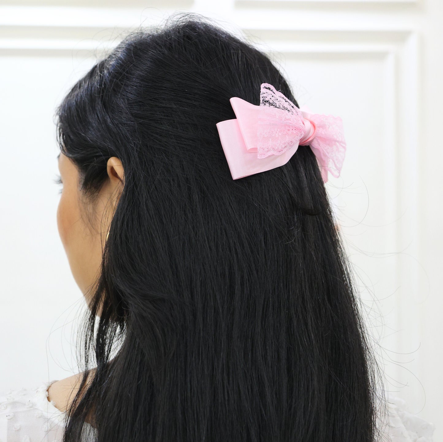 Woman styling Glory Bow in Pink – romantic pastel hair accessory by Tesral Accessories