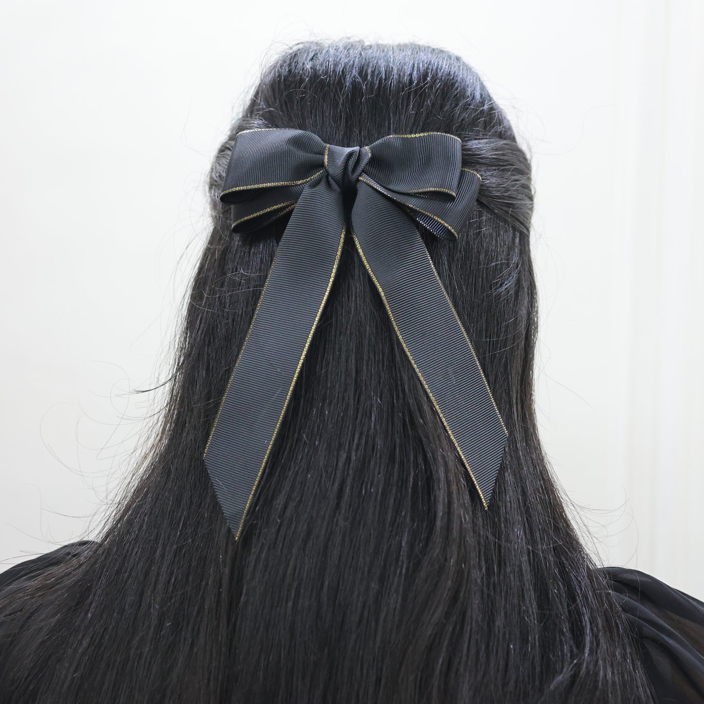 Elegant woman styling Golden Grace Bow – sophisticated hair accessory by Tesral Accessories