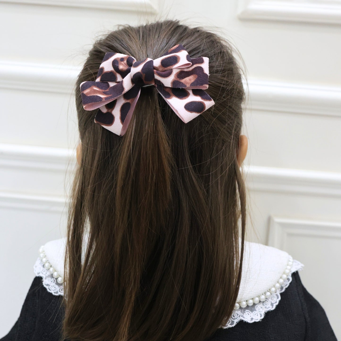Model styling Tesral Leopard Luxe Hair Bow to elevate a casual or evening look with animal print flair.