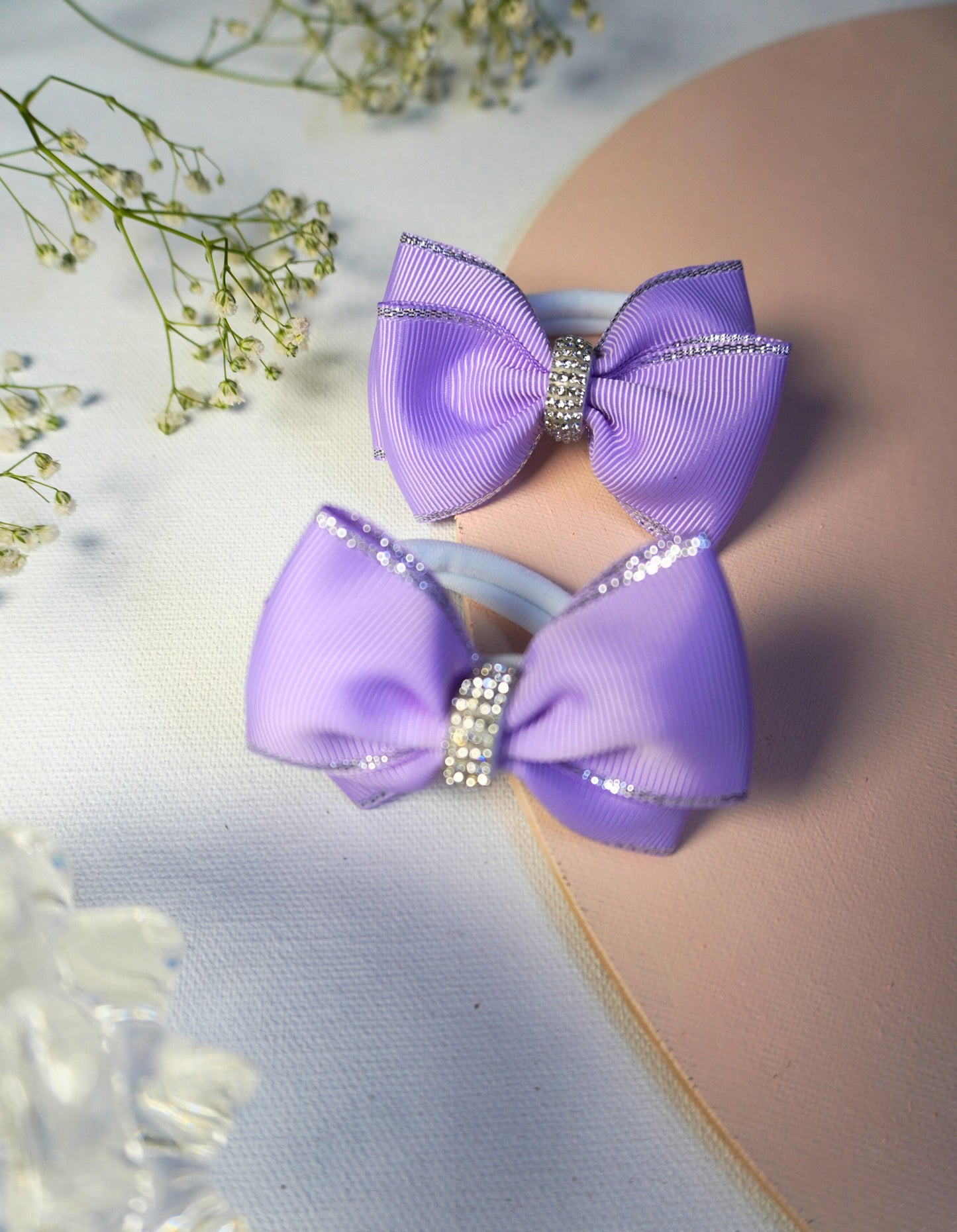 Detailed view of sparkling rhinestone hair tie in lilac grosgrain ribbon for toddlers and girls
