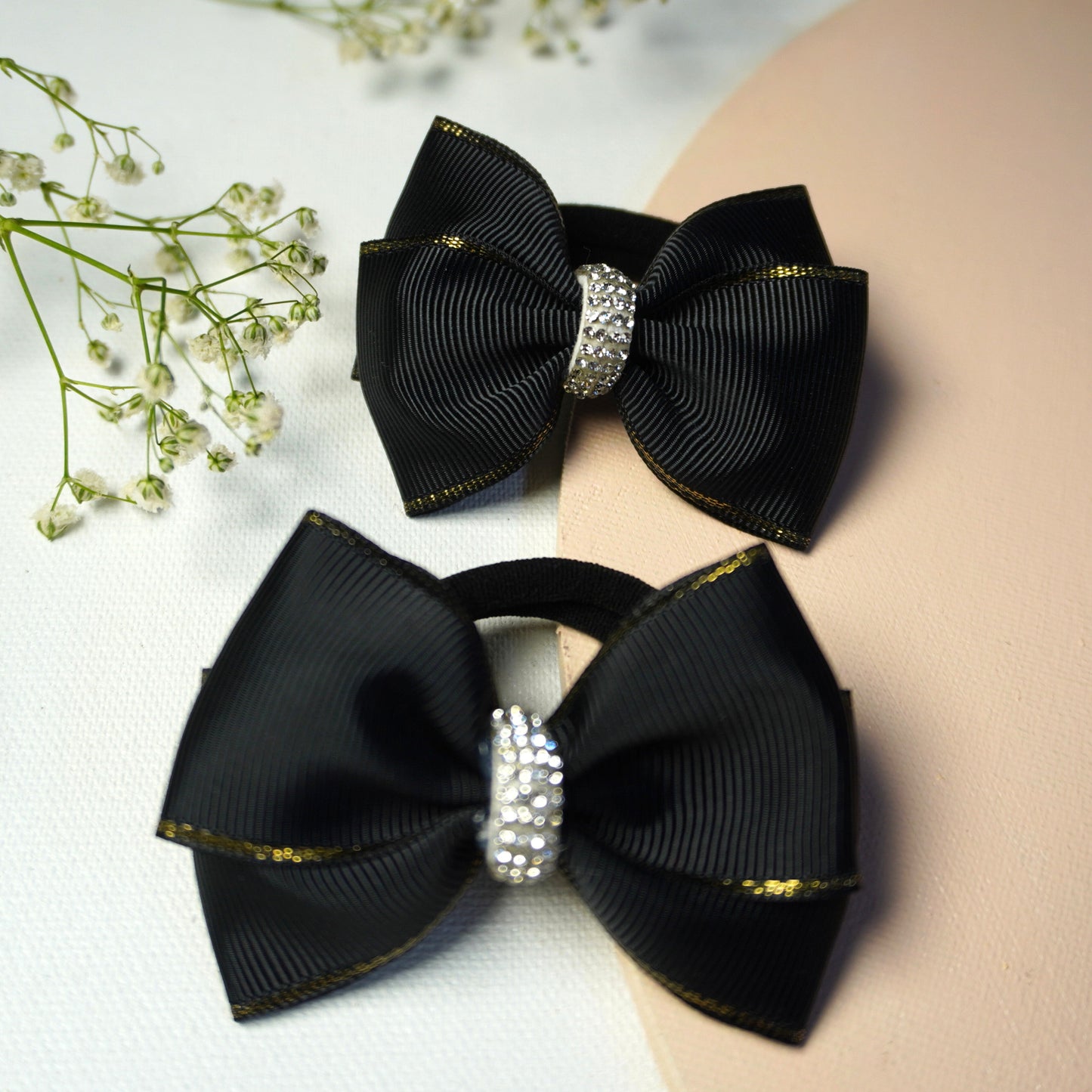 Detailed macro view of black ribbon bow with shimmering rhinestone center and golden border