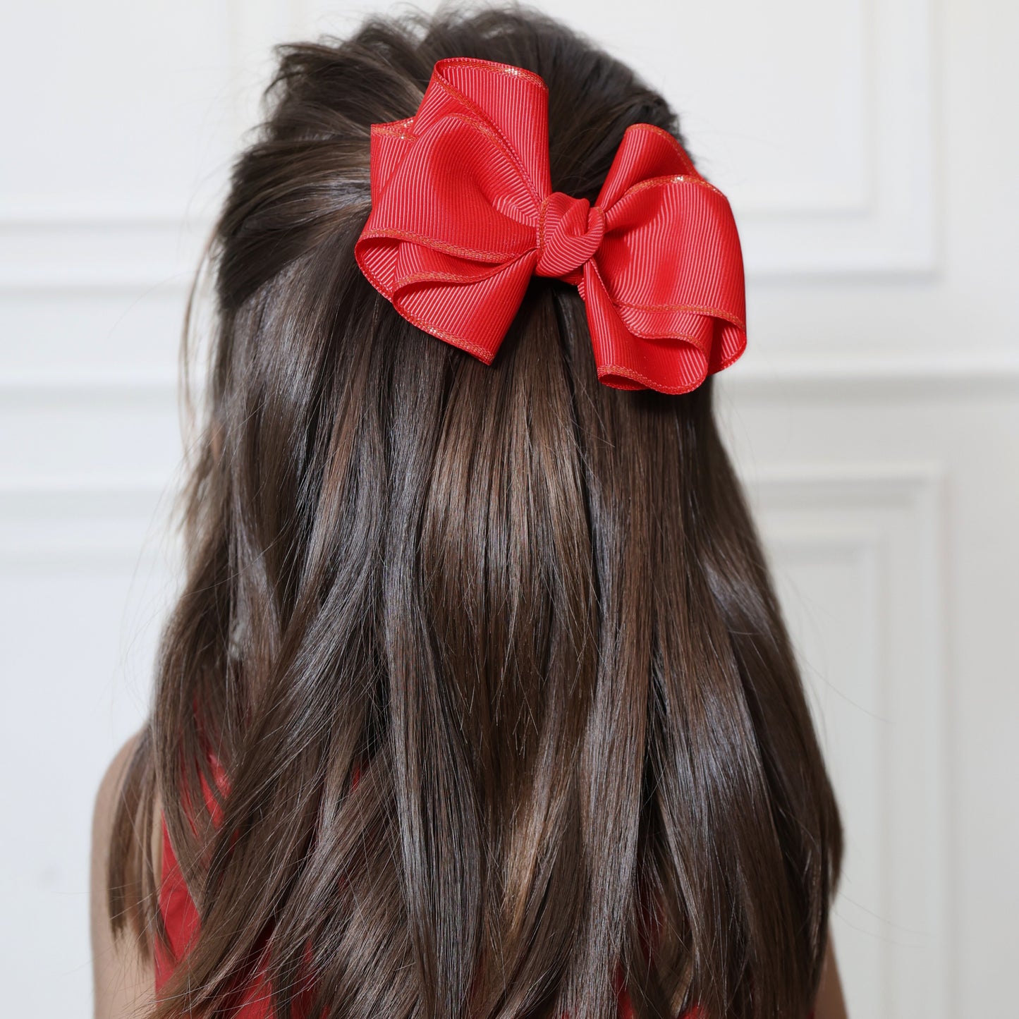 Girl wearing Tesral Party Pop Hair Bow to add colorful charm to birthday or party hairstyle.