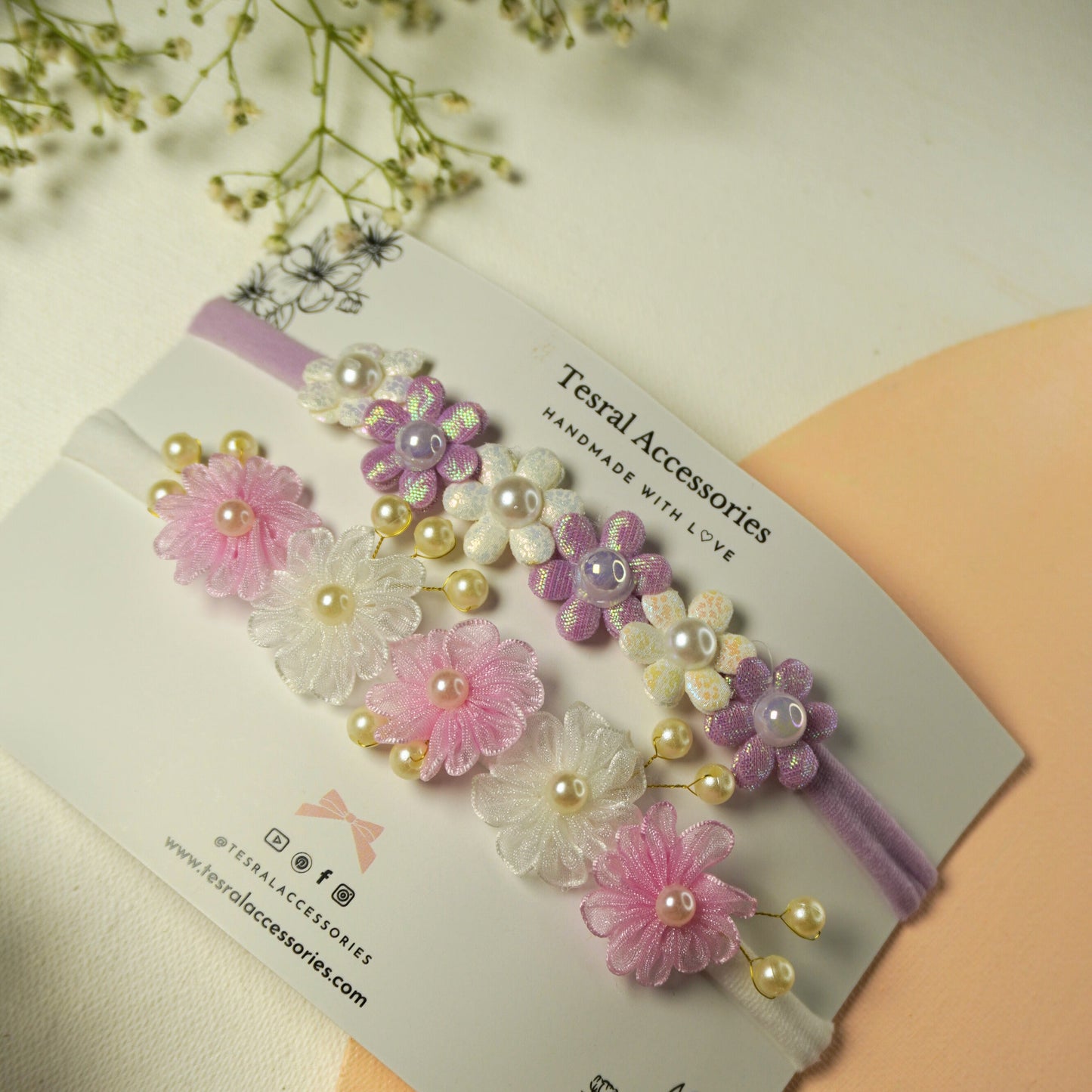 Set of two pastel flower headbands with pearl details in purple/white and pink/white