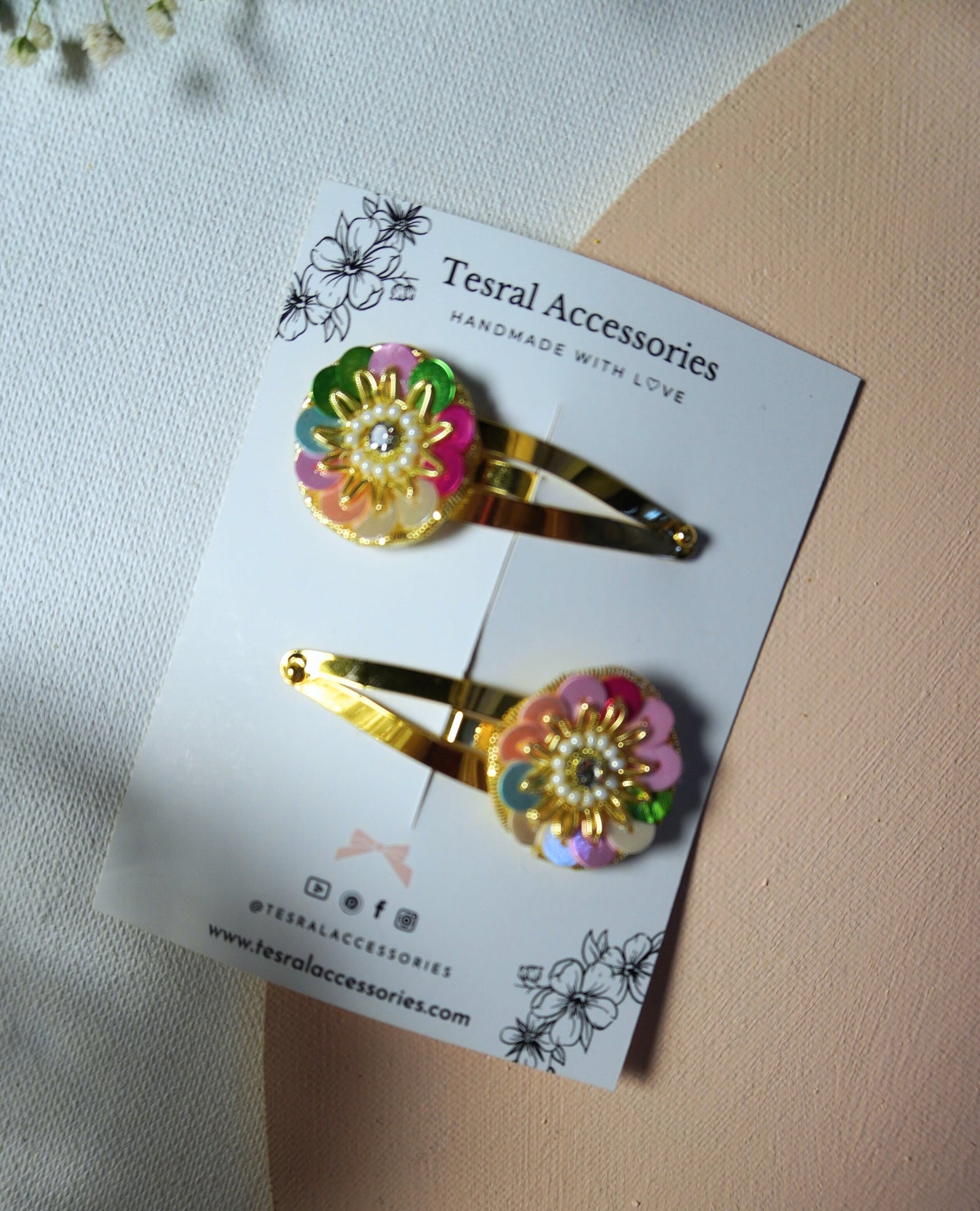 Close-up of Tesral Accessories Rainbow Radiance festive flower hair clips on golden snap clips