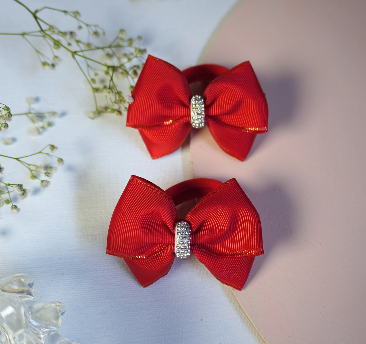 Close-up of red grosgrain ribbon hair bow with rhinestone centerpiece and golden-edged detail – Tesral Accessories