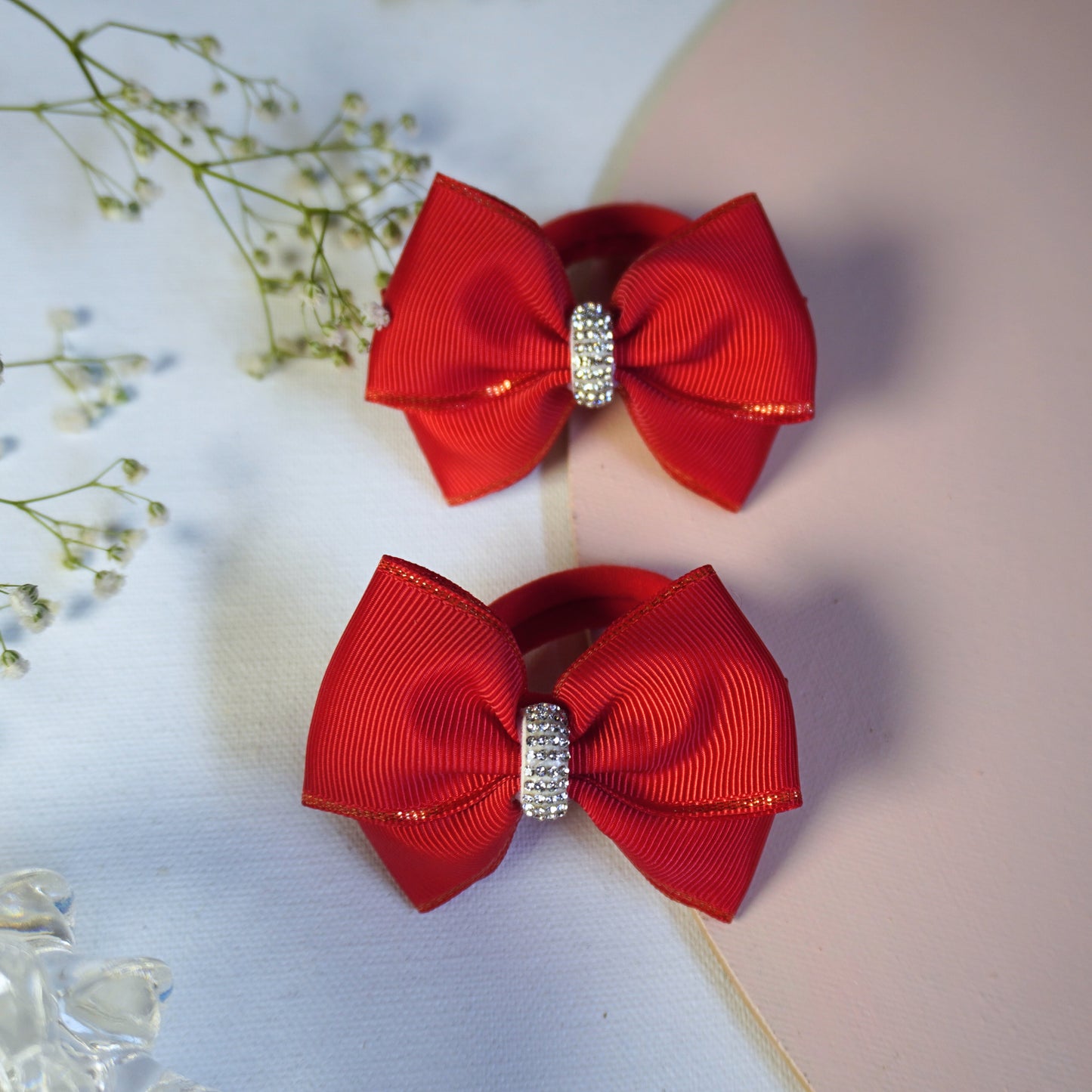 Detailed view of red grosgrain bow hair tie with crystal center and shimmer edge for girls