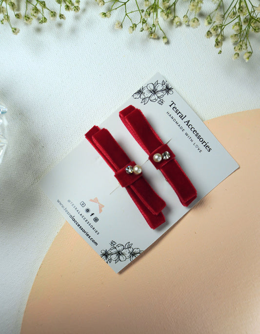 Close-up of luxury red velvet bow hair pin with pearl and rhinestone details
