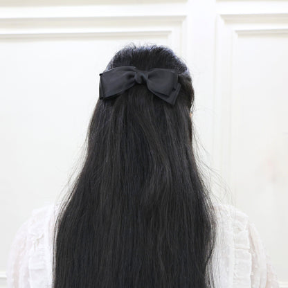 Model wearing Tesral Diana Bow in Black, displaying its formal elegance and sophisticated presence in an upscale hairstyle.