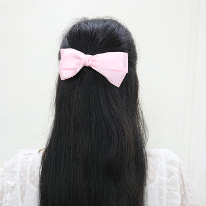 Model wearing Tesral Diana Bow in Pearly Pink, showcasing joyful charm and polished silhouette as a standout hair accessory.