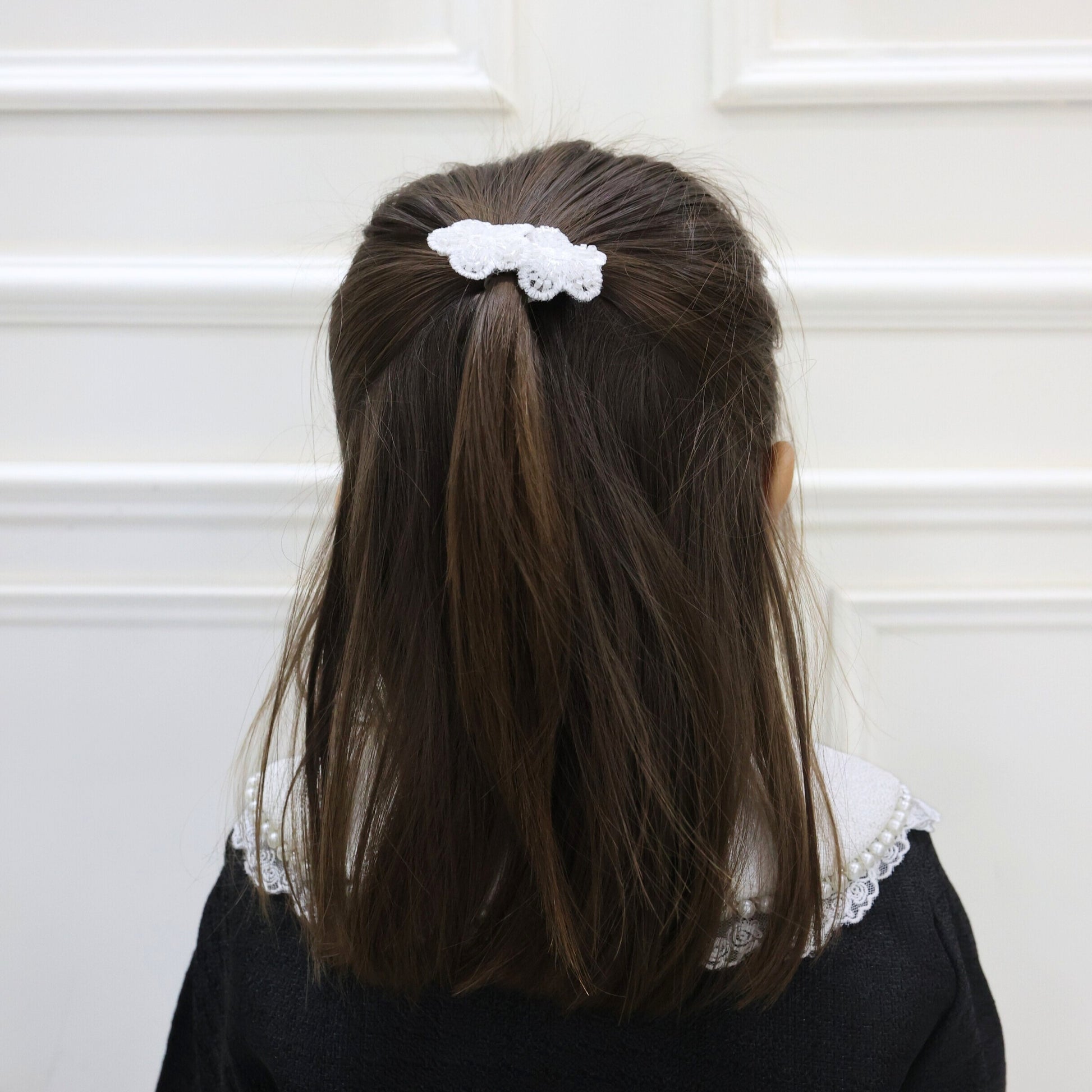 Model wearing Tesral Embellished Bloom Clips in hair, demonstrating how floral appliqués add graceful sparkle to a hairstyle.