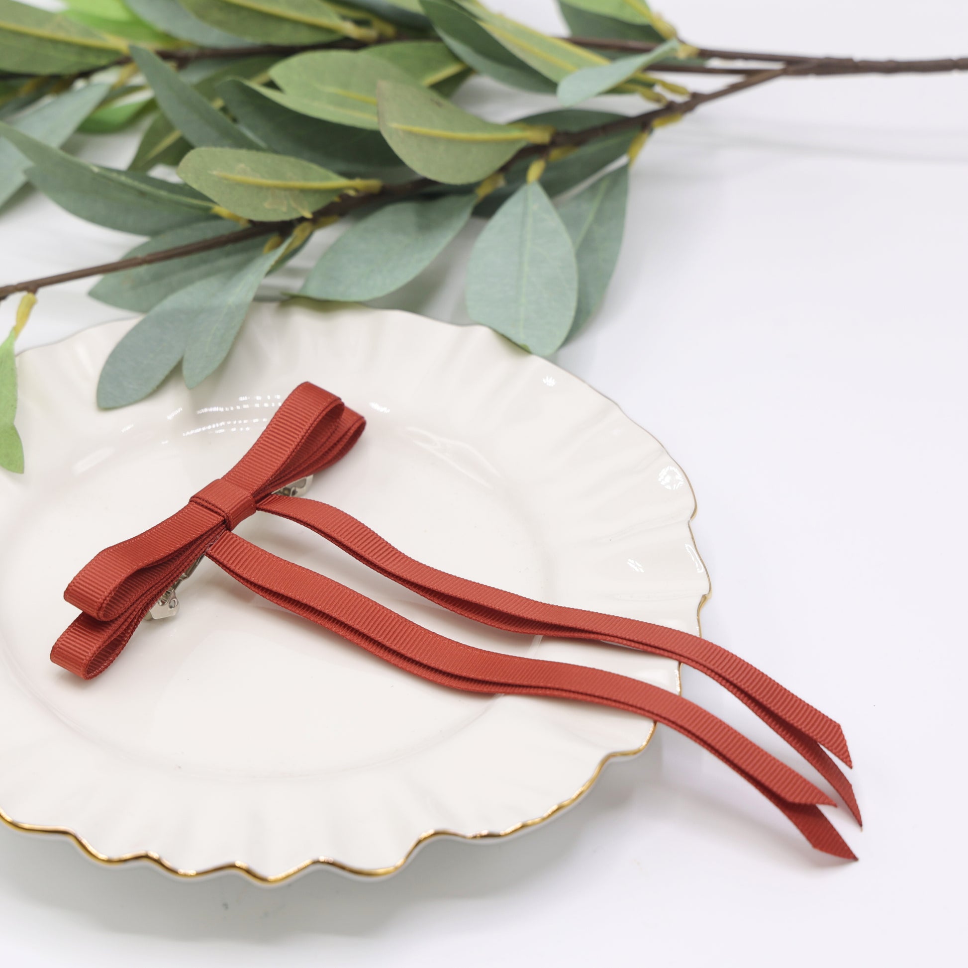 Close-up of Tesral Ethereal Rust Hair Bow, showing ribbed texture of grosgrain ribbon and secure barrette clip.