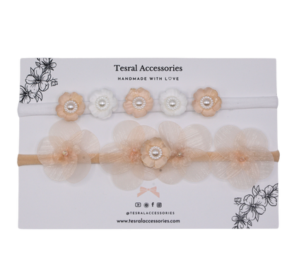 Close-up of Set of two peach petals and white blossoms with pearls on Tiara Bloom headbands. 