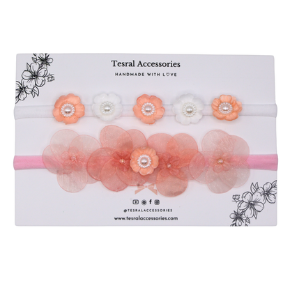 A set of two headbands with flowers in shades of pink and white, displayed in packaging with the brand Tesral Accessories