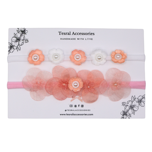 A set of two headbands with flowers in shades of pink and white, displayed in packaging with the brand Tesral Accessories