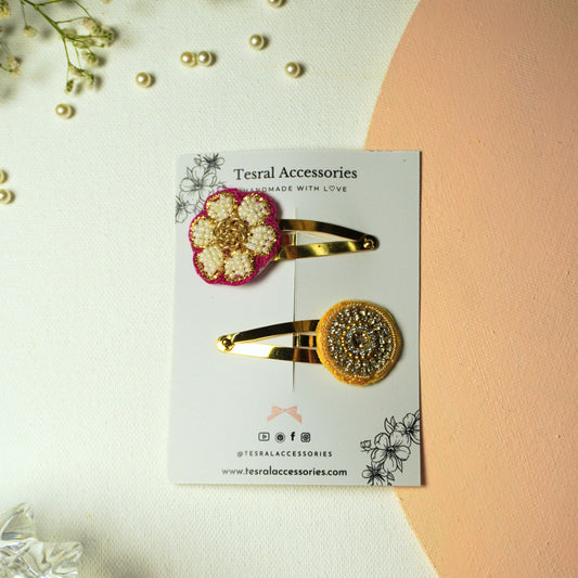 Set of two gold snap clips with beaded appliqués: magenta flower and golden circle