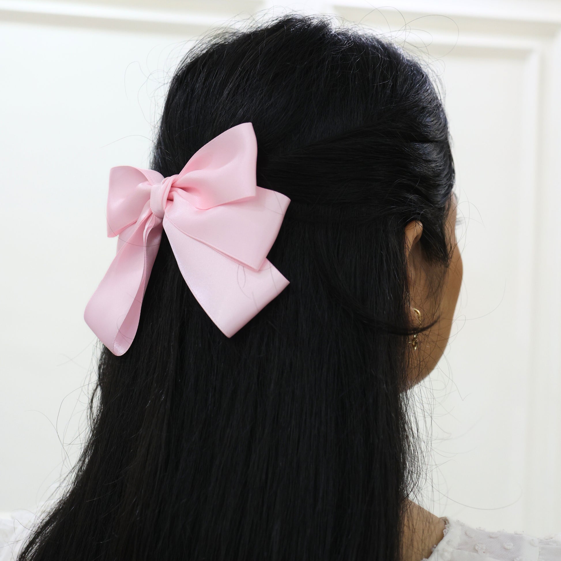 Woman wearing Grace Bow in pastel pink – feminine everyday or occasion hair bow by Tesral Accessories