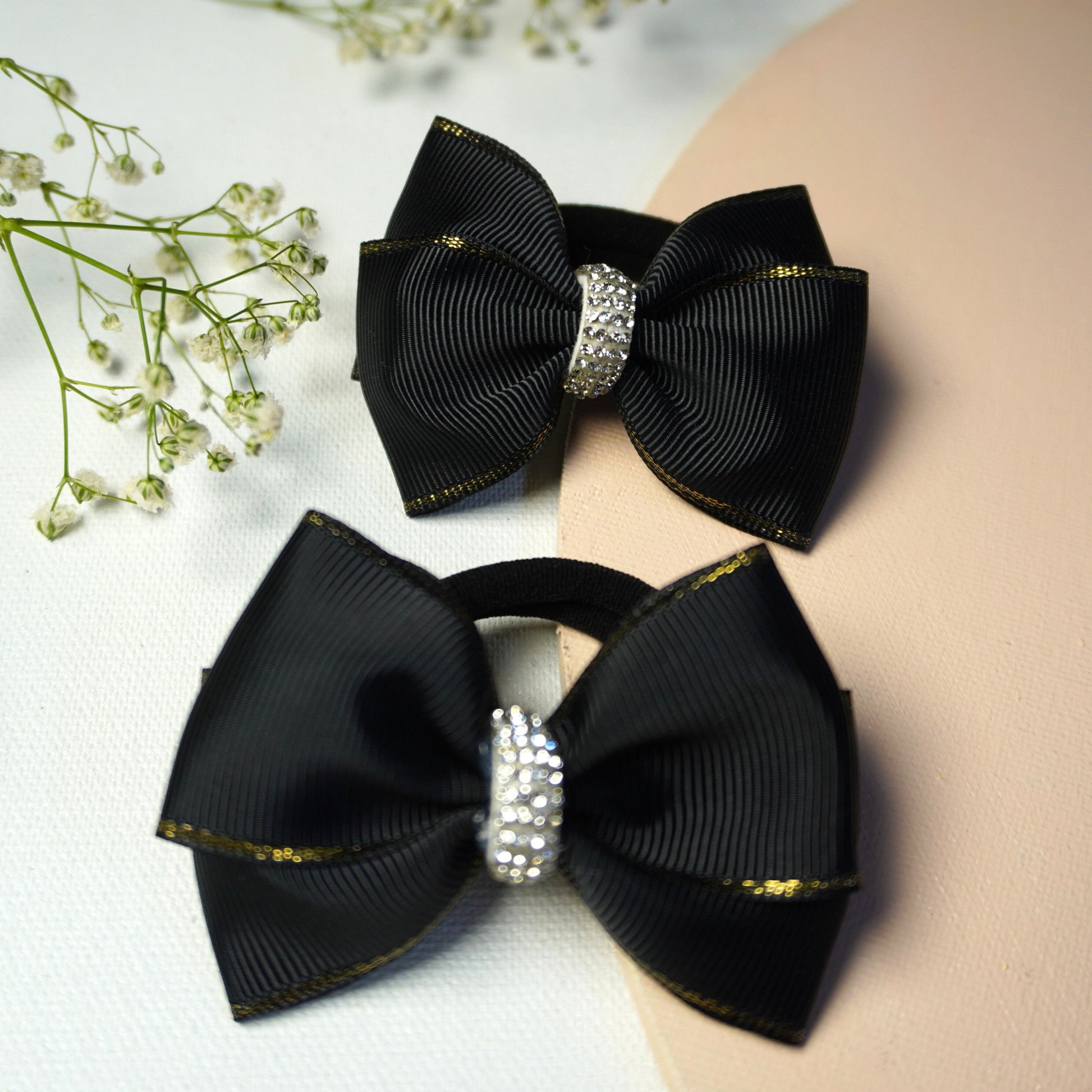 Detailed macro view of black ribbon bow with shimmering rhinestone center and golden border