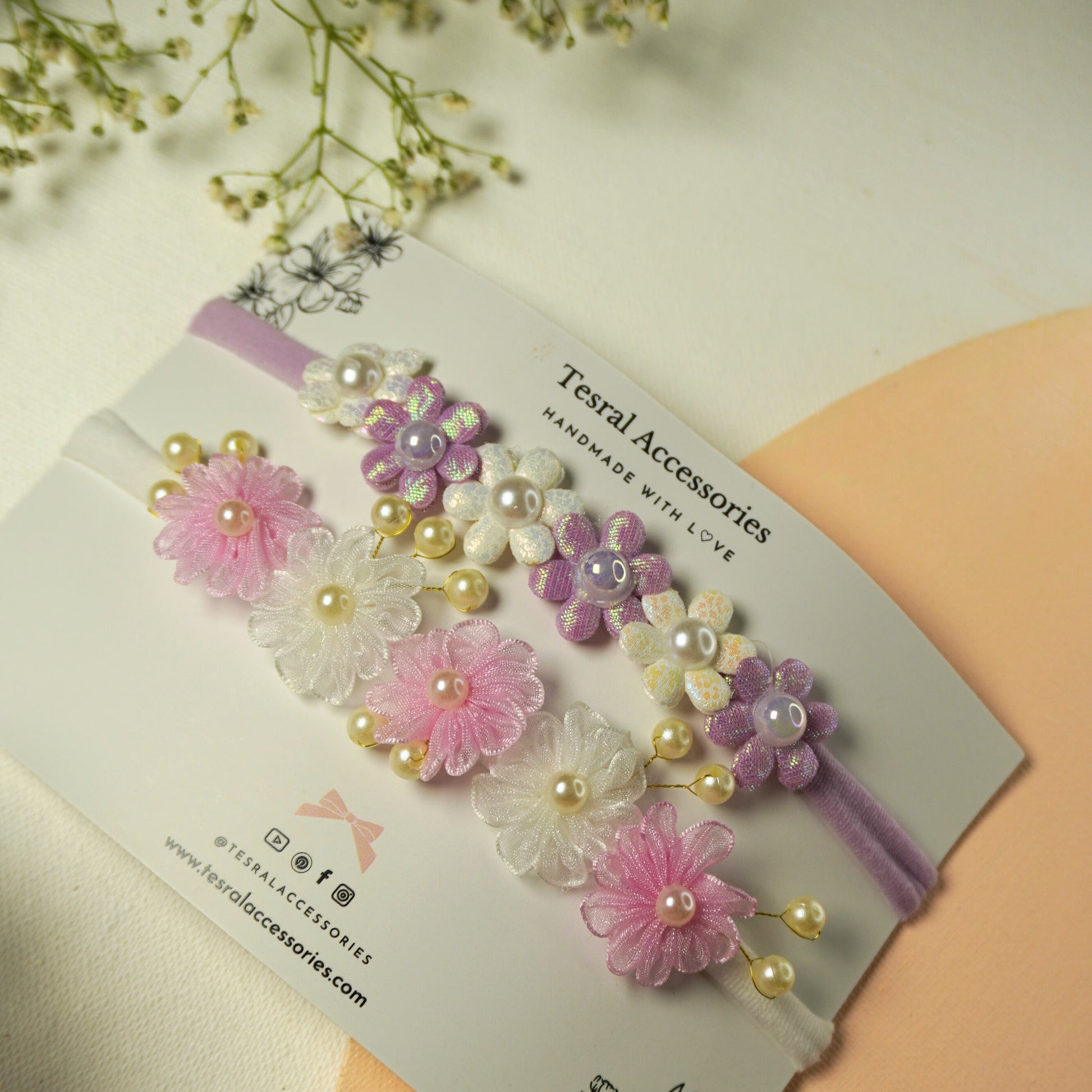 Set of two pastel flower headbands with pearl details in purple/white and pink/white
