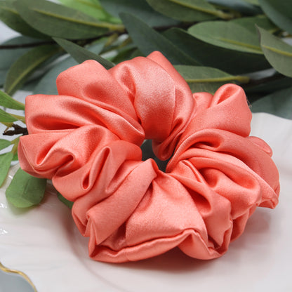 Close-up of Peach Whirl Scrunchie showing smooth satin finish and gentle stretch texture.