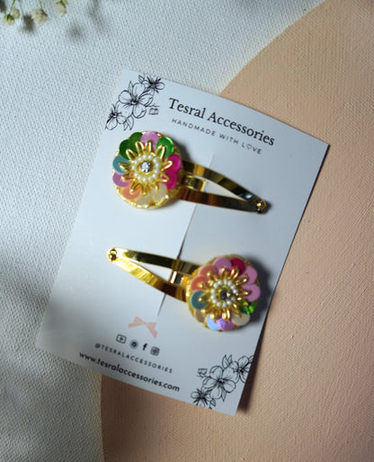 Close-up of Tesral Accessories Rainbow Radiance festive flower hair clips on golden snap clips