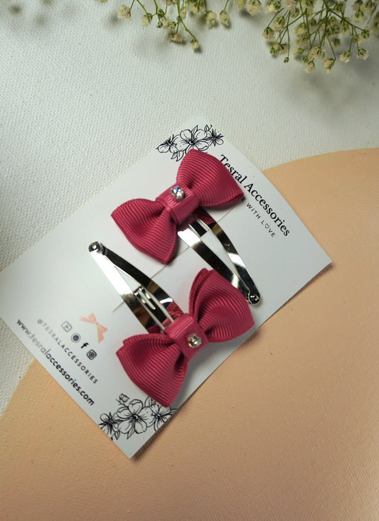 Close-up of silver snap clip set with pink textured ribbon bow and small rhinestone
