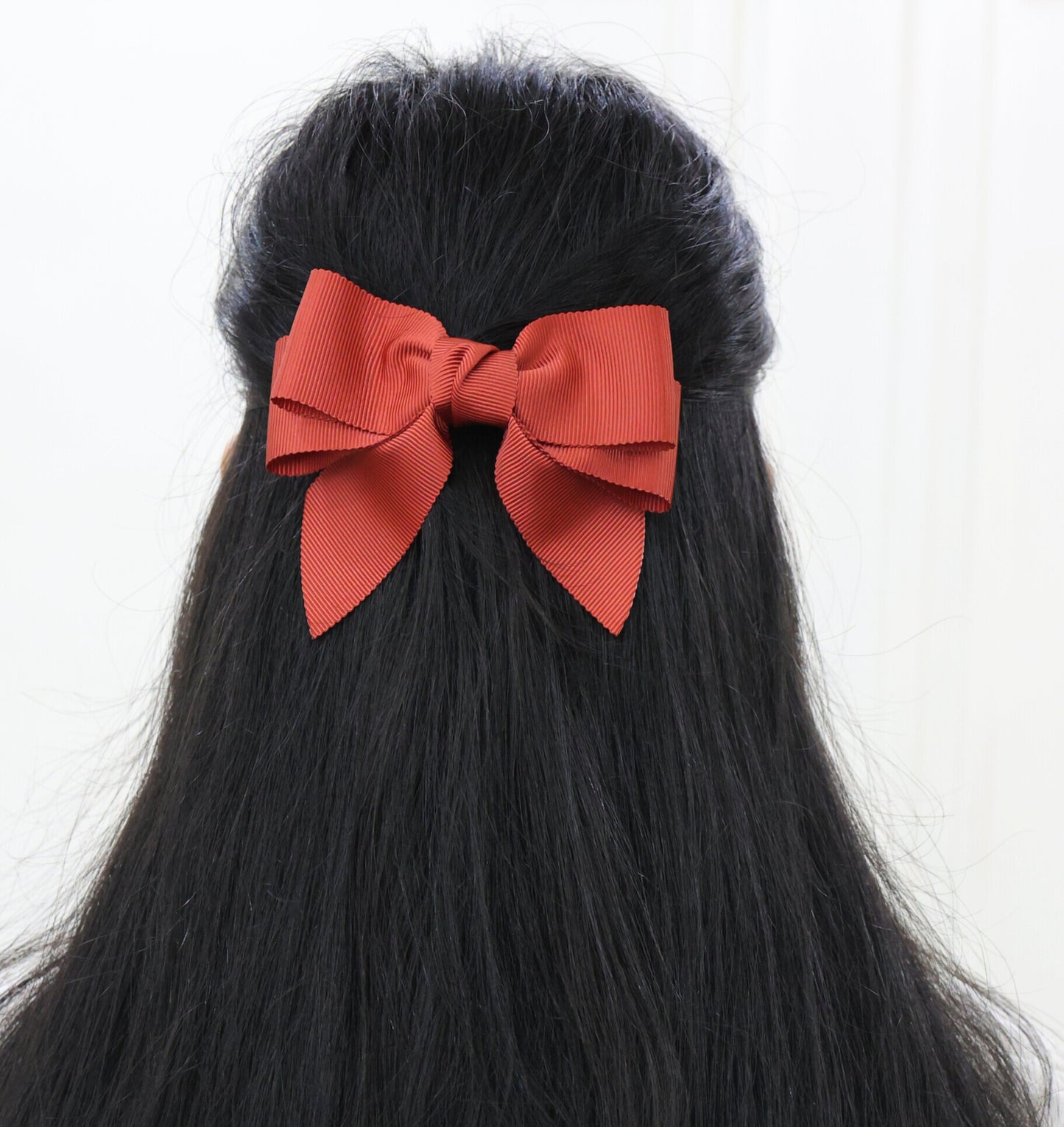 Woman wearing Rustique hair bow made from rust petersham grosgrain ribbon – double-layer barrette clip by Tesral Accessories