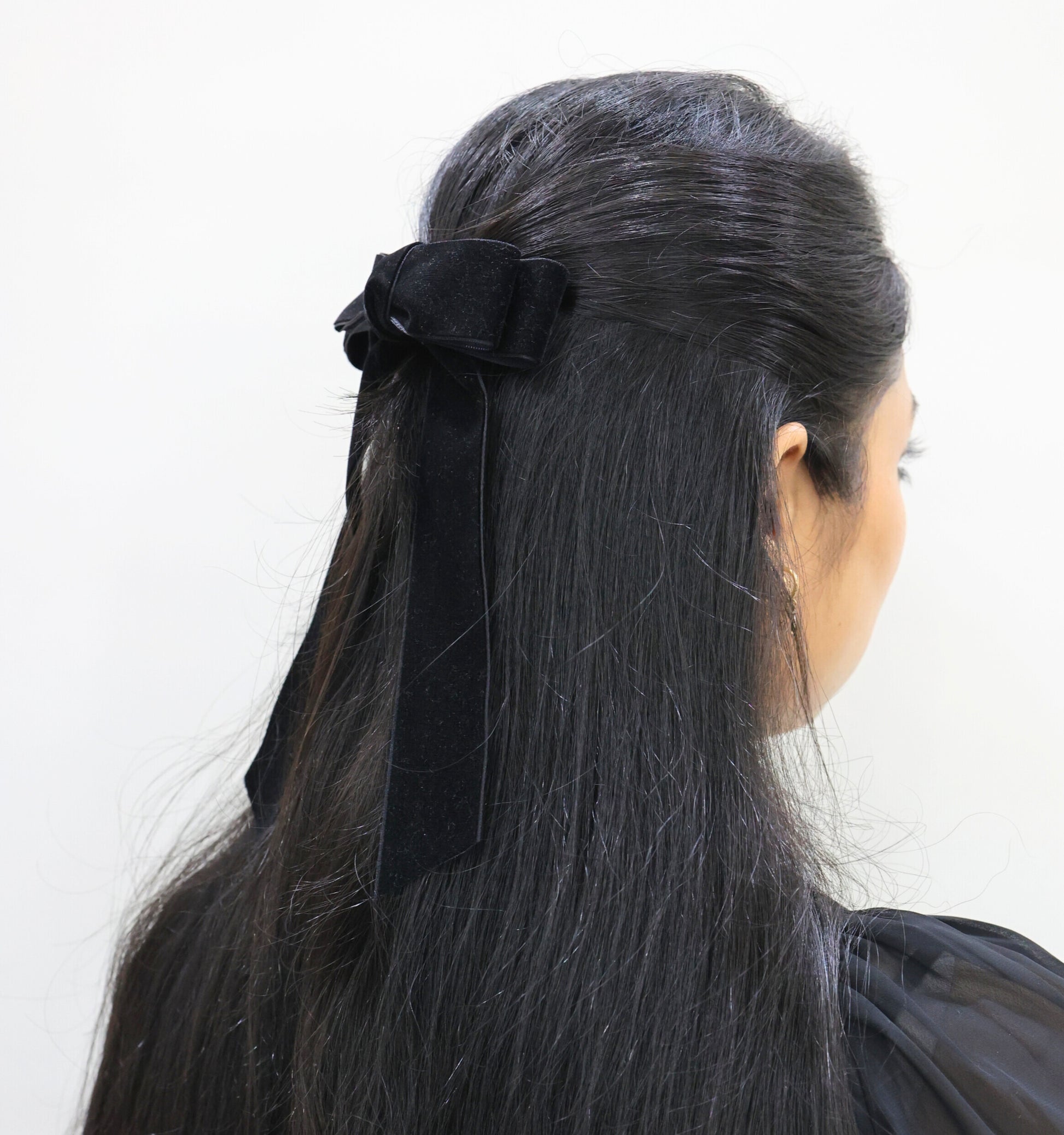 Woman wearing black velvet Serenity hair bow with long tails – elegant barrette hair accessory by Tesral Accessories
